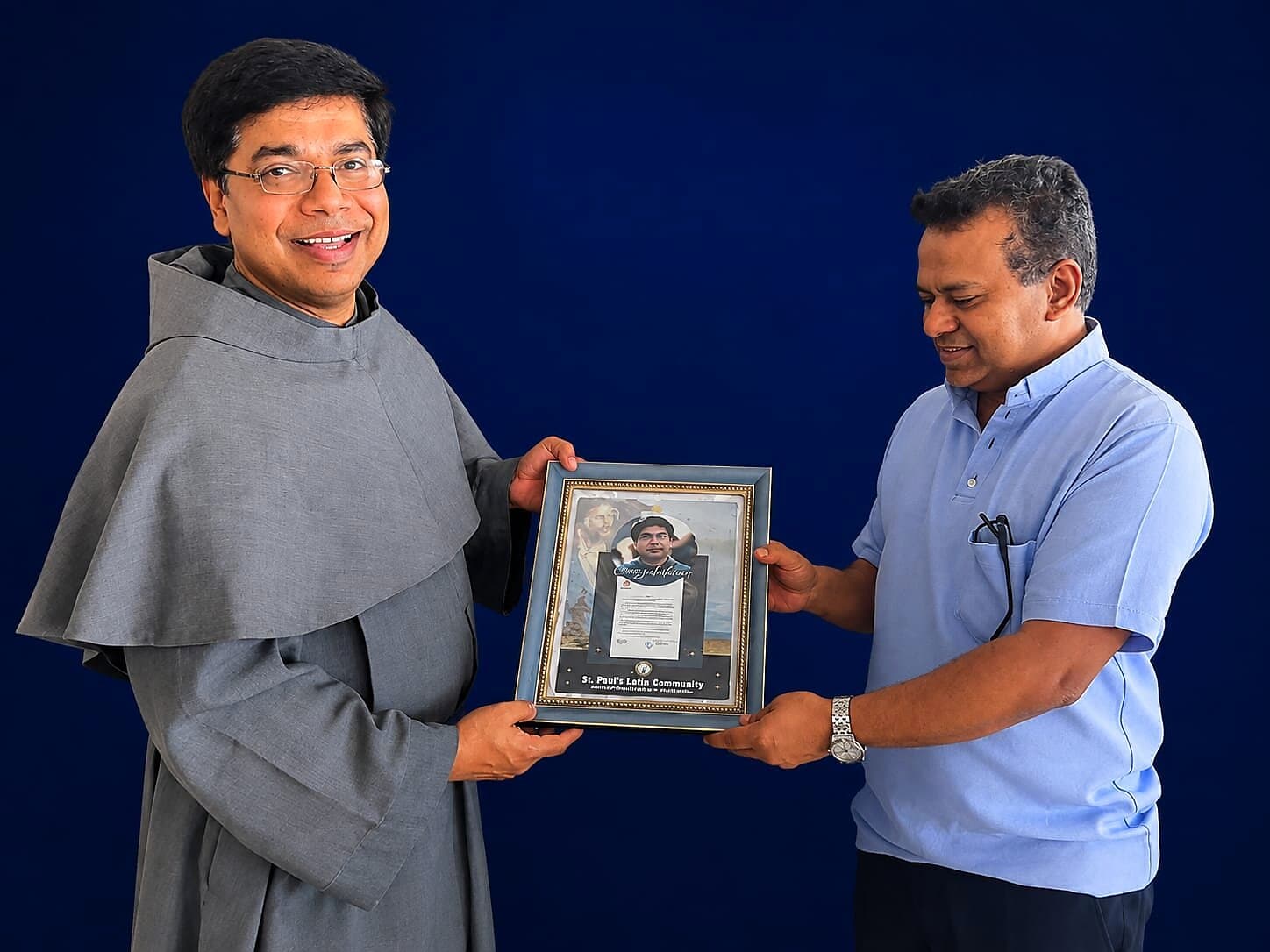 Fr. Damian Veliyil receiving a commemorative plaque marking the Archbishop's decree, June 2024